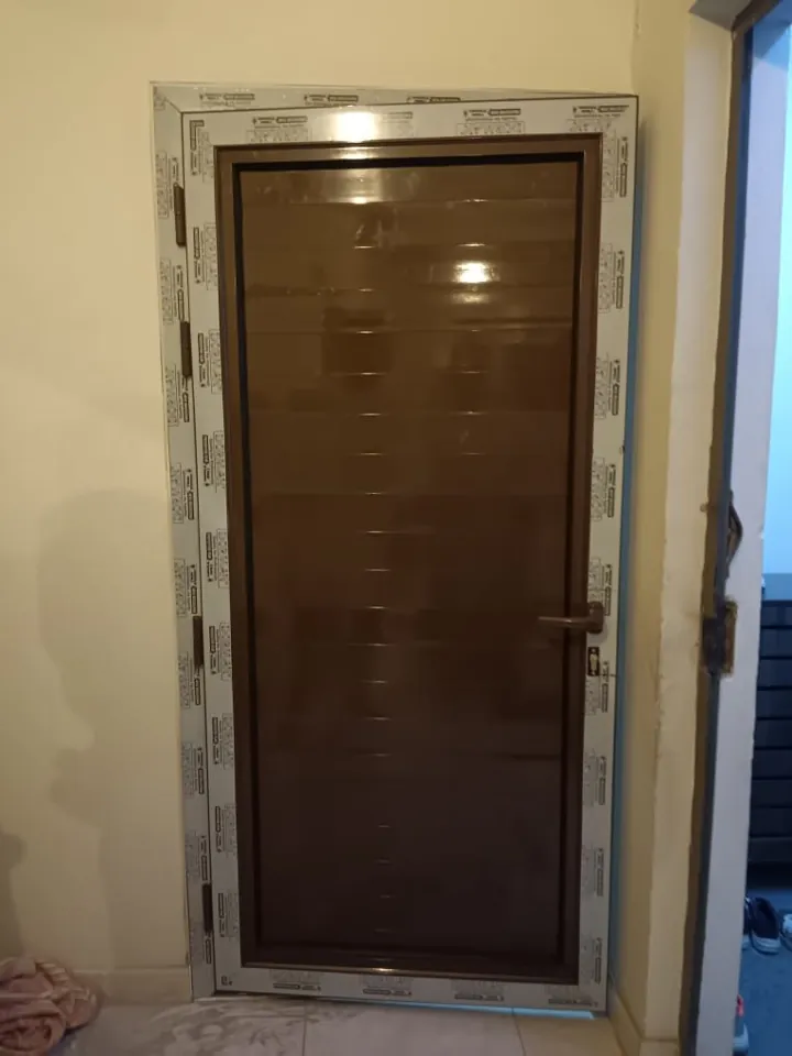 Dark wood-tone entrance door — Marhaba Aluminium & Metal Works