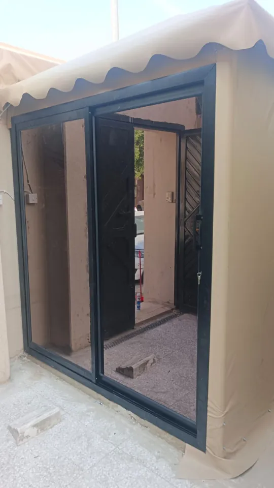 Dark-framed sliding glass entrance — Marhaba Aluminium & Metal Works